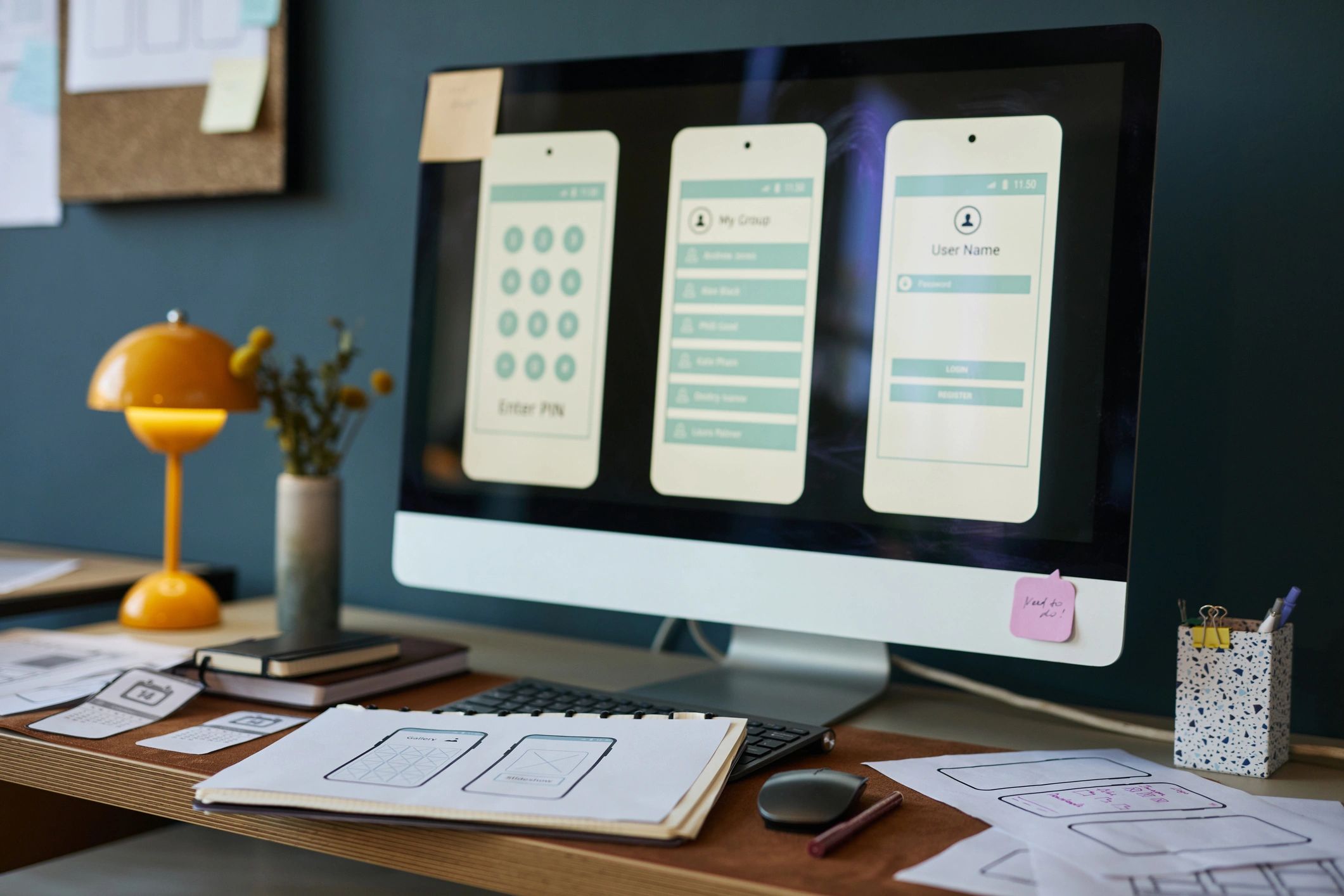 Computer monitor showing interface design sketches in a modern office