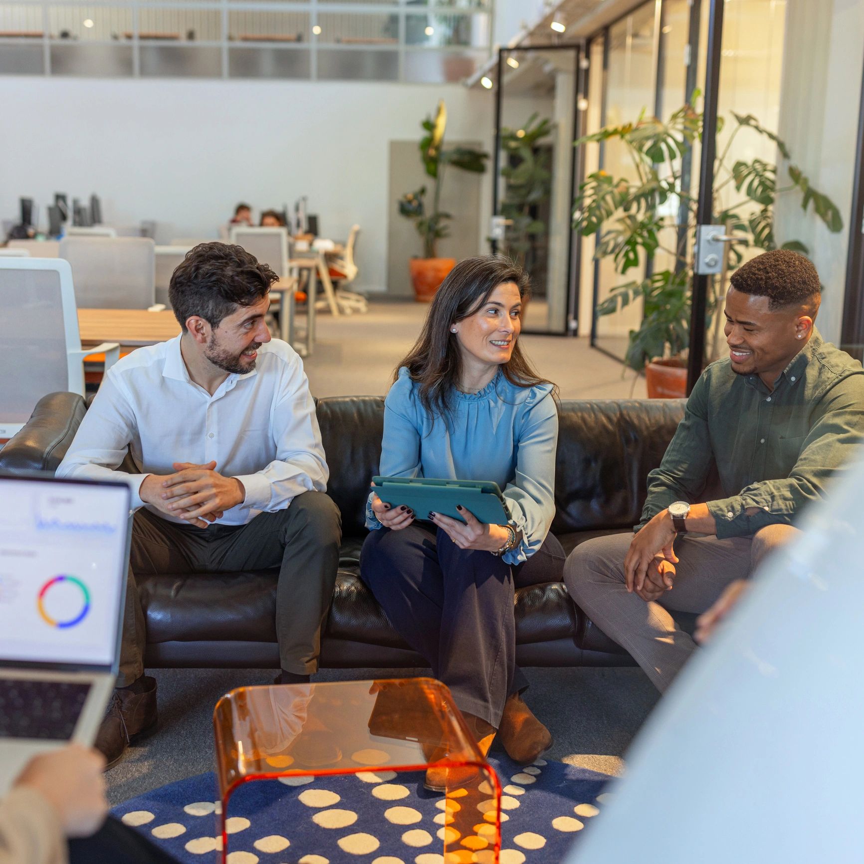 Business team collaborating and smiling in a modern office lounge
