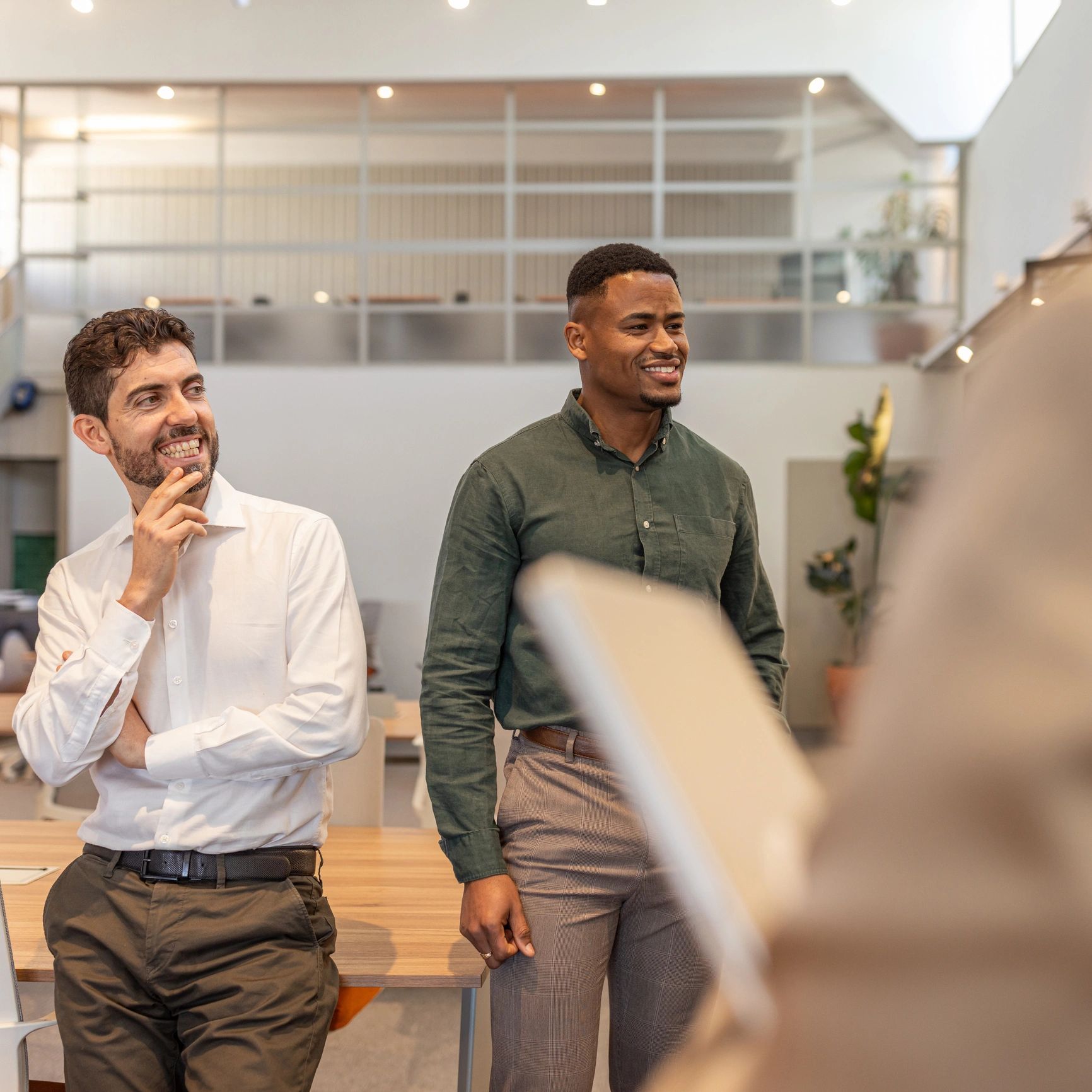Smiling colleagues in modern office during casual team discussion